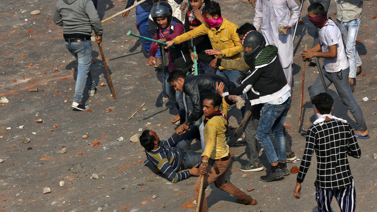 A man is beaten during a clash between people supporting a new citizenship law and those opposing the law in New Delhi